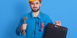 mężczyzna w kasku trzymający narzędzia